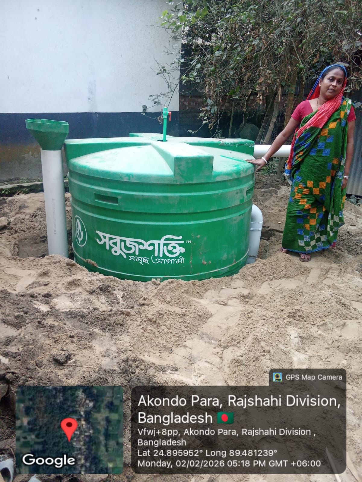 Biodigester installation with household beneficiary beside tank